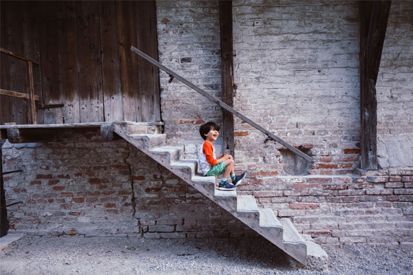 Junge auf einer Holztreppe